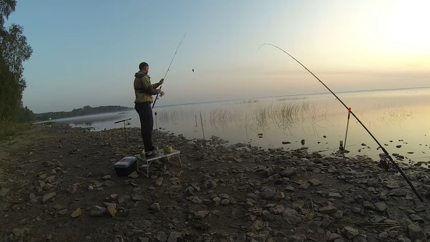 Рыбак ловит рыбу с каменного берега 1